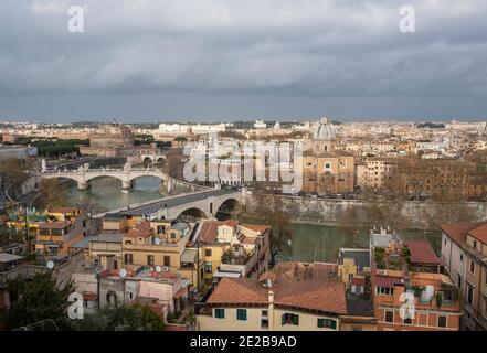Blick über den Tiber und die Brücken ins Zentrum Roms von Trastevere. Die Kirche von San Giovanni Battista dei Fiorentini am Flussufer. Stockfoto