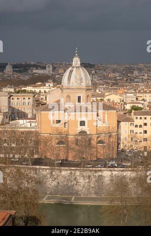 Blick von Trastevere über den Tiber ins Zentrum von Rom, Italien. Kirche San Giovanni Battista dei Fiorentini am Flussufer. Stockfoto