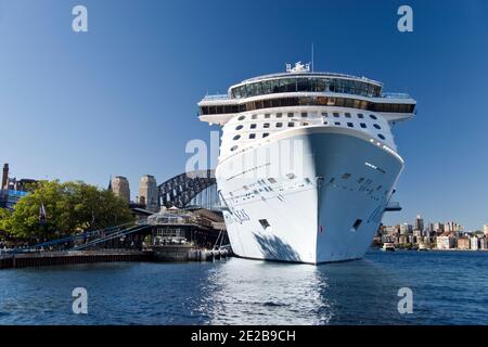 Ein Kreuzfahrtschiff liegt im Hafen von Sydney, mit der Harbour Bridge im Hintergrund, Sydney, Australien. Stockfoto