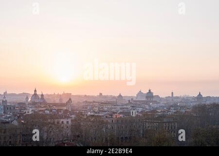 Atmosphärische Luftaufnahme von Rom, Italien, von Trastevere bei Sonnenaufgang, mit Wahrzeichen historischen Gebäuden silhouetted in dunstigen Morgenlicht. Stockfoto