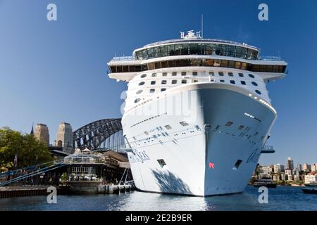 Ein Kreuzfahrtschiff liegt im Hafen von Sydney, mit der Harbour Bridge im Hintergrund, Sydney, Australien. Stockfoto