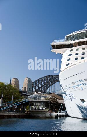 Ein Kreuzfahrtschiff liegt im Hafen von Sydney, mit der Harbour Bridge im Hintergrund, Sydney, Australien. Stockfoto