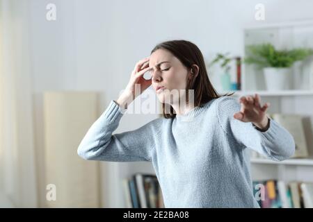Schwindelerregende Frau mit Schwindelanfall im Wohnzimmer stehend Zu Hause Stockfoto