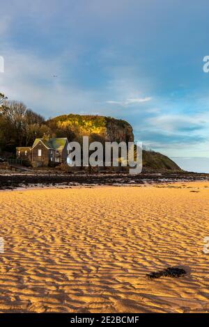 Ein Blick am späten Nachmittag auf Castell Mawr Rock auf Red Wharf Bay bei Ebbe im Winter, Anglesey, Wales Stockfoto