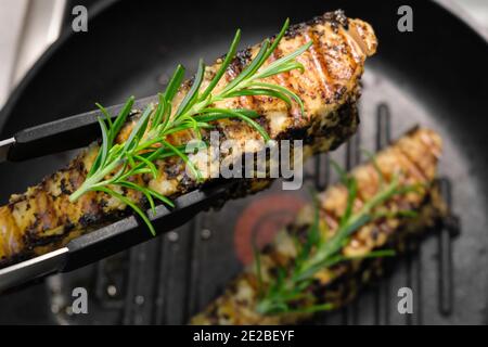 Geröstetes Lachsfischfilet mit Rosmarin auf einem Grillstift. Hausgemachtes gesundes Abendessen Stockfoto