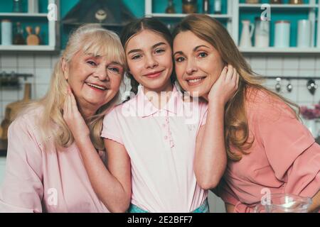 Cincematic Bild von einer älteren Frau und ihrer Tochter und Enkelin Backen und Kochen Essen in ihrer schönen Küche. Großmutter bereitet Kuchen und Stockfoto