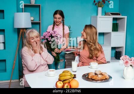 Cincematic Bild einer älteren Frau und ihre Tochter und Enkelin beim gemeinsamen Frühstück Stockfoto