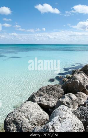 Die Wellenbrecher Steine und kristallklares Wasser auf Freeport Stadt Lucaya Strand auf Grand Bahama Insel. Stockfoto