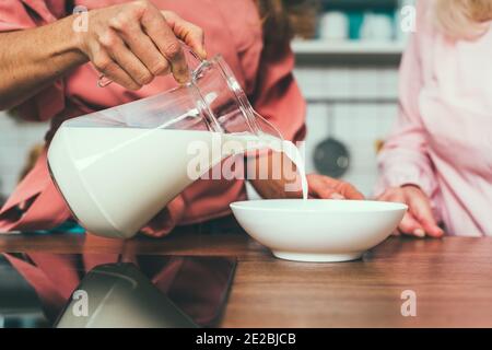 Cincematic Bild von einer älteren Frau und ihre Tochter Backen und Kochen Essen in ihrer schönen Küche. Großmutter bereitet Kuchen und Süßigkeiten für die Stockfoto