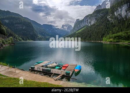 Ausflugsboote vertäuten am Holzsteg im Vorderer Gosausee bei Gosau, umgeben vom Dachsteingebirge im Sommer, Gmunden, Oberösterreich Stockfoto