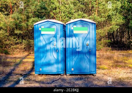Zwei blaue Plastikkabinen. Öffentliche Toilette im Stadtpark. Chemische Toilette Haus auf einer Baustelle. Bio-Toilette im Erholungsgebiet. Stockfoto