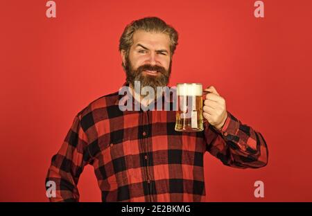 Oktoberfest. Bierkneipe. Stilvoller Barkeeper oder Barkeeper in der Bar. Erholung. Mann halten ein Glas Bier. Hipster an der Bar Zähler. Spaß beim Fußball beobachten. Brutal bärtiger Mann trinkt Bier aus Glas. Stockfoto