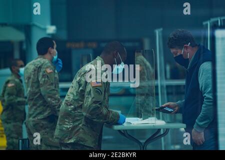 New York, New York, USA. Januar 2021. Ein Mitglied der US Army National Guard kontrolliert Menschen, da der Staat New York am 13. Januar 2021 in New York eine Massenimpfstelle im Jacob Javits Convention Center auf der West Side Manhattans eröffnet. Quelle: Bryan Smith/ZUMA Wire/Alamy Live News Stockfoto