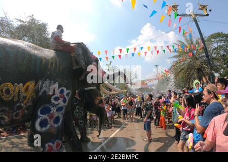 Mahout und sein Elefant spritzt spielerisch Wasser. Young Elephant Spaß und Glück in Songkran Festival. Stockfoto