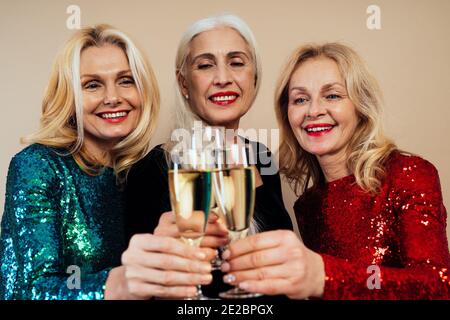 Schöne ältere Frau macht Party und feiert Neujahr. Frauen mittleren Alters tragen elegante glitzernde Kleider und Spaß haben. Studio Portraits ein Stockfoto