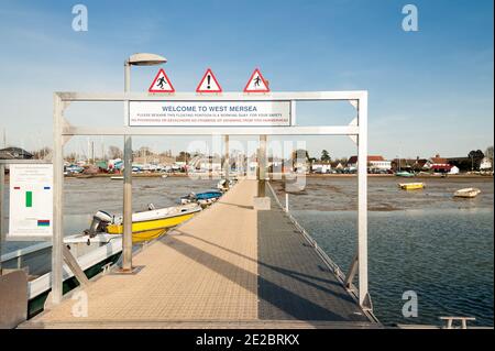 WEST MERSEA, ESSEX, UK - 05. APRIL 2009: Blick entlang der Anlegestelle zurück zur Insel mit Willkommensschild Stockfoto