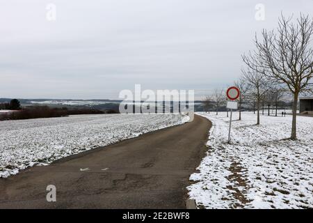 Ansicht des Kreises Straßenschild in einem Feld entlang der Straße an einem frostigen Wintermorgen Stockfoto