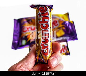 Norwich, Norfolk, Großbritannien – Dezember 24 2020. Ein illustratives redaktionelles Foto eines nicht identifizierbaren Menschen, der eine Cadbury Crunchie-Schokoriegel hält Stockfoto