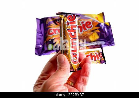 Norwich, Norfolk, Großbritannien – Dezember 24 2020. Ein illustratives redaktionelles Foto eines nicht identifizierbaren Menschen, der eine Cadbury Crunchie-Schokoriegel hält Stockfoto