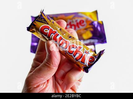 Norwich, Norfolk, Großbritannien – Dezember 24 2020. Ein illustratives redaktionelles Foto eines nicht identifizierbaren Menschen, der eine Cadbury Crunchie-Schokoriegel hält Stockfoto