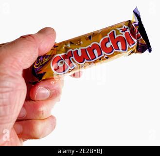 Norwich, Norfolk, Großbritannien – Dezember 24 2020. Ein illustratives redaktionelles Foto eines nicht identifizierbaren Menschen, der eine Cadbury Crunchie-Schokoriegel hält Stockfoto