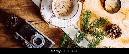 Cappuccino auf einem Holztisch, Touristenkarte und Kamera. Langes Banner Stockfoto