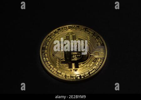 Einzelne goldene wertvolle Bitcoin auf schwarzem Hintergrund in der Mitte Anzeigen Stockfoto