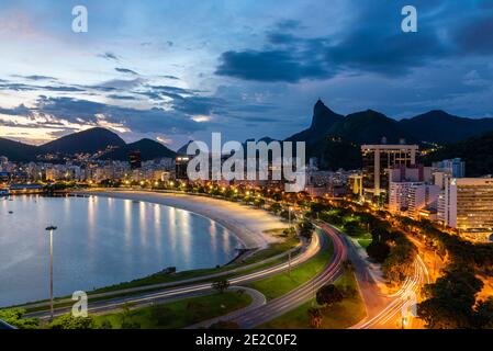 Schöne blaue Stunde Blick auf den Strand, Berge, Auto Licht Wanderwege und Stadtgebäude in Rio de Janeiro, Brasilien Stockfoto