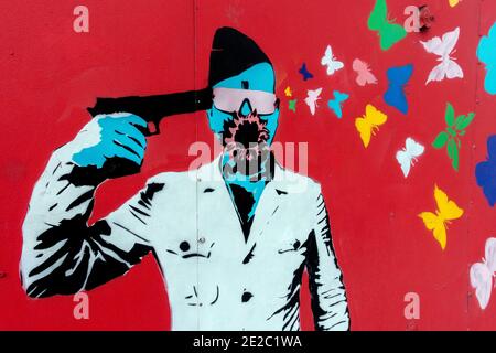 Stencil Street Art Graffiti Mann Waffe und Schmetterlinge Prag Stockfoto