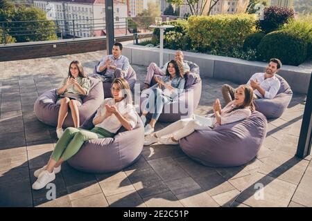 Portrait von netten erfahrenen fröhlichen Unternehmern sitzen in Tasche Stuhl Lautsprecher Kutscher klatschen Handflächen auf dem Dach frische Luft draußen Im Freien Stockfoto