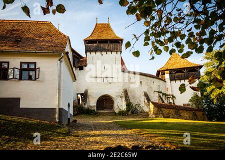 Die mittelalterliche sächsische Wehrkirche von Viscri eingerahmt von den Herbstbäumen Ästen. Foto aufgenommen am 2. Oktober 2020 in Viscri, Siebenbürgen Region, Stockfoto