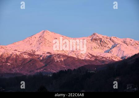 Profil einer Piemontesischen Alp mit Blick auf die Po-Ebene eingetaucht In einem rosa Sonnenuntergang Stockfoto