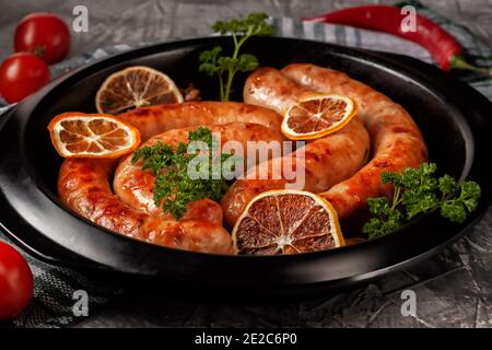In einer Bratpfanne, hausgemachte Hühnerwurst in Gewürzen und mit Zitrone Stockfoto