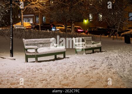 Parkbänke im schneebedeckten Taka-Töölön Bezirk von Helsinki, Finnland Stockfoto