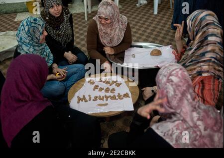 Die Frauen von Misrata trafen sich in Zusammenarbeit, um ihre Unterstützung für die Revolution zu geben, sind in Libyen, am 29. September 2011 abgebildet. Jeden Tag treffen sie sich um 8:00 bis 13:00 Uhr und bereiten die Mahlzeiten für die Kämpferinnen im Gesicht, aber auch für das Krankenhaus zu. Seit dem 1. Juli werden fast 3000 Mahlzeiten pro Tag zubereitet. Alle oder fast verloren ein Mitglied ihrer Familie in diesem Krieg. Sie entschieden sich also, sich an den Kriegsbemühungen zu beteiligen, die sie auf ihren Weg brachten. Sie sind ungefähr fünfzig, die jeden Tag gefunden werden. Das ermöglicht ihnen, sich zu treffen, sich zu trösten, zu diskutieren. Sie halten eine wesentliche soziale Verbindung so alle, während sie nützlich gemacht. Pho Stockfoto