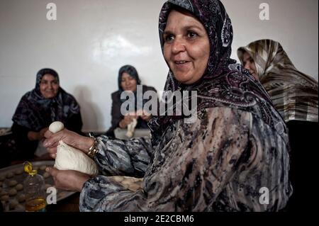 Die Frauen von Misrata trafen sich in Zusammenarbeit, um ihre Unterstützung für die Revolution zu geben, sind in Libyen, am 29. September 2011 abgebildet. Jeden Tag treffen sie sich um 8:00 bis 13:00 Uhr und bereiten die Mahlzeiten für die Kämpferinnen im Gesicht, aber auch für das Krankenhaus zu. Seit dem 1. Juli werden fast 3000 Mahlzeiten pro Tag zubereitet. Alle oder fast verloren ein Mitglied ihrer Familie in diesem Krieg. Sie entschieden sich also, sich an den Kriegsbemühungen zu beteiligen, die sie auf ihren Weg brachten. Sie sind ungefähr fünfzig, die jeden Tag gefunden werden. Das ermöglicht ihnen, sich zu treffen, sich zu trösten, zu diskutieren. Sie halten eine wesentliche soziale Verbindung so alle, während sie nützlich gemacht. Pho Stockfoto