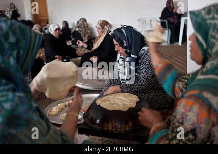 Die Frauen von Misrata trafen sich in Zusammenarbeit, um ihre Unterstützung für die Revolution zu geben, sind in Libyen, am 29. September 2011 abgebildet. Jeden Tag treffen sie sich um 8:00 bis 13:00 Uhr und bereiten die Mahlzeiten für die Kämpferinnen im Gesicht, aber auch für das Krankenhaus zu. Seit dem 1. Juli werden fast 3000 Mahlzeiten pro Tag zubereitet. Alle oder fast verloren ein Mitglied ihrer Familie in diesem Krieg. Sie entschieden sich also, sich an den Kriegsbemühungen zu beteiligen, die sie auf ihren Weg brachten. Sie sind ungefähr fünfzig, die jeden Tag gefunden werden. Das ermöglicht ihnen, sich zu treffen, sich zu trösten, zu diskutieren. Sie halten eine wesentliche soziale Verbindung so alle, während sie nützlich gemacht. Pho Stockfoto