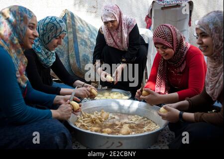 Die Frauen von Misrata trafen sich in Zusammenarbeit, um ihre Unterstützung für die Revolution zu geben, sind in Libyen, am 29. September 2011 abgebildet. Jeden Tag treffen sie sich um 8:00 bis 13:00 Uhr und bereiten die Mahlzeiten für die Kämpferinnen im Gesicht, aber auch für das Krankenhaus zu. Seit dem 1. Juli werden fast 3000 Mahlzeiten pro Tag zubereitet. Alle oder fast verloren ein Mitglied ihrer Familie in diesem Krieg. Sie entschieden sich also, sich an den Kriegsbemühungen zu beteiligen, die sie auf ihren Weg brachten. Sie sind ungefähr fünfzig, die jeden Tag gefunden werden. Das ermöglicht ihnen, sich zu treffen, sich zu trösten, zu diskutieren. Sie halten eine wesentliche soziale Verbindung so alle, während sie nützlich gemacht. Pho Stockfoto