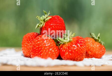 Nahaufnahme von frischen Erdbeeren leuchtend rot im Glas auf einem Holzhintergrund. Stockfoto