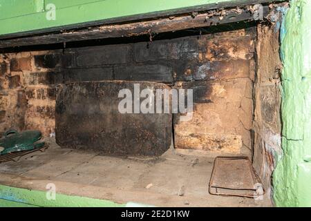 Antiker russischer Ofen, Metallverschluss und einige antike Gerichte in einem Dorfhaus Stockfoto