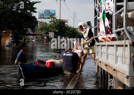 Flutopfer machen ihren Weg durch ein überflutetes Viertel im Ban Mai Distrikt von Bangkok, nördlich des Flughafens Don Muang, als steigende Wasser Teile von Bangkok, Thailand, bedrohen 26. Oktober 2011. Hunderte von Fabriken schlossen in der zentralen thailändischen Provinz Ayutthaya und Nonthaburi, als das Hochwasser Bangkok zu erreichen begann. Nach Angaben des Department of Disaster Prevention and Mitigation sind seit Ende Juli rund 370 Menschen bei Hochwasserereignissen ums Leben gekommen, wobei Thailand die schlimmsten Überschwemmungen seit 50 Jahren erlebt hat. Foto von Frederic Belge/ABACAPRESS.COM Stockfoto