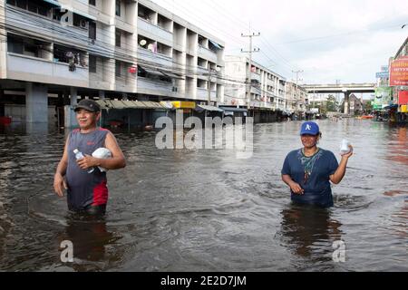 Flutopfer machen ihren Weg durch ein überflutetes Viertel im Ban Mai Distrikt von Bangkok, nördlich des Flughafens Don Muang, als steigende Wasser Teile von Bangkok, Thailand, bedrohen 26. Oktober 2011. Hunderte von Fabriken schlossen in der zentralen thailändischen Provinz Ayutthaya und Nonthaburi, als das Hochwasser Bangkok zu erreichen begann. Nach Angaben des Department of Disaster Prevention and Mitigation sind seit Ende Juli rund 370 Menschen bei Hochwasserereignissen ums Leben gekommen, wobei Thailand die schlimmsten Überschwemmungen seit 50 Jahren erlebt hat. Foto von Frederic Belge/ABACAPRESS.COM Stockfoto