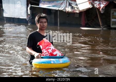 Flutopfer machen ihren Weg durch ein überflutetes Viertel im Ban Mai Distrikt von Bangkok, nördlich des Flughafens Don Muang, als steigende Wasser Teile von Bangkok, Thailand, bedrohen 26. Oktober 2011. Hunderte von Fabriken schlossen in der zentralen thailändischen Provinz Ayutthaya und Nonthaburi, als das Hochwasser Bangkok zu erreichen begann. Nach Angaben des Department of Disaster Prevention and Mitigation sind seit Ende Juli rund 370 Menschen bei Hochwasserereignissen ums Leben gekommen, wobei Thailand die schlimmsten Überschwemmungen seit 50 Jahren erlebt hat. Foto von Frederic Belge/ABACAPRESS.COM Stockfoto