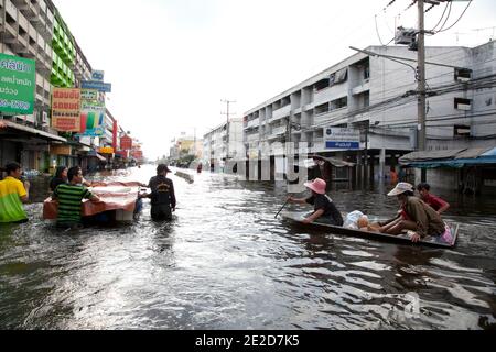 Flutopfer machen ihren Weg durch ein überflutetes Viertel im Ban Mai Distrikt von Bangkok, nördlich des Flughafens Don Muang, als steigende Wasser Teile von Bangkok, Thailand, bedrohen 26. Oktober 2011. Hunderte von Fabriken schlossen in der zentralen thailändischen Provinz Ayutthaya und Nonthaburi, als das Hochwasser Bangkok zu erreichen begann. Nach Angaben des Department of Disaster Prevention and Mitigation sind seit Ende Juli rund 370 Menschen bei Hochwasserereignissen ums Leben gekommen, wobei Thailand die schlimmsten Überschwemmungen seit 50 Jahren erlebt hat. Foto von Frederic Belge/ABACAPRESS.COM Stockfoto