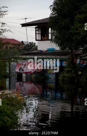 Flutopfer machen ihren Weg durch ein überflutetes Viertel im Ban Mai Distrikt von Bangkok, nördlich des Flughafens Don Muang, als steigende Wasser Teile von Bangkok, Thailand, bedrohen 26. Oktober 2011. Hunderte von Fabriken schlossen in der zentralen thailändischen Provinz Ayutthaya und Nonthaburi, als das Hochwasser Bangkok zu erreichen begann. Nach Angaben des Department of Disaster Prevention and Mitigation sind seit Ende Juli rund 370 Menschen bei Hochwasserereignissen ums Leben gekommen, wobei Thailand die schlimmsten Überschwemmungen seit 50 Jahren erlebt hat. Foto von Frederic Belge/ABACAPRESS.COM Stockfoto