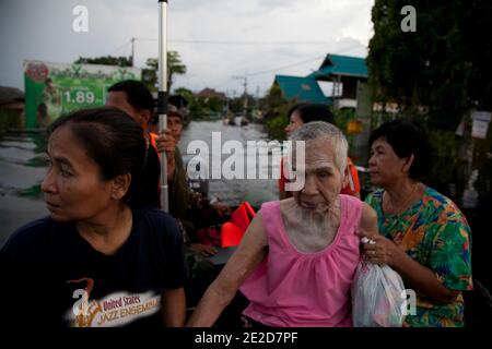 Flutopfer machen ihren Weg durch ein überflutetes Viertel im Ban Mai Distrikt von Bangkok, nördlich des Flughafens Don Muang, als steigende Wasser Teile von Bangkok, Thailand, bedrohen 26. Oktober 2011. Hunderte von Fabriken schlossen in der zentralen thailändischen Provinz Ayutthaya und Nonthaburi, als das Hochwasser Bangkok zu erreichen begann. Nach Angaben des Department of Disaster Prevention and Mitigation sind seit Ende Juli rund 370 Menschen bei Hochwasserereignissen ums Leben gekommen, wobei Thailand die schlimmsten Überschwemmungen seit 50 Jahren erlebt hat. Foto von Frederic Belge/ABACAPRESS.COM Stockfoto