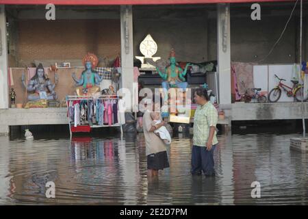 Flutopfer machen ihren Weg durch ein überflutetes Viertel in einem Tempel in Bangkoks nördlichem Stadtteil Phatum Thani, während steigende Wasser Teile von Bangkok, Thailand, bedrohen 28. Oktober 2011. Hunderte von Fabriken schlossen in der zentralen thailändischen Provinz Ayutthaya und Nonthaburi, als das Hochwasser Bangkok zu erreichen begann. Nach Angaben des Department of Disaster Prevention and Mitigation sind seit Ende Juli rund 370 Menschen bei Hochwasserereignissen ums Leben gekommen, wobei Thailand die schlimmsten Überschwemmungen seit 50 Jahren erlebt hat. Foto von Frederic Belge/ABACAPRESS.COM Stockfoto