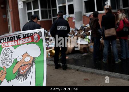 Polizeibeamte und Journalisten stehen vor den Büros des französischen Satiremagazins Charlie Hebdo, nachdem sie über Nacht durch einen Benzinbombenanschlag zerstört wurden. Das Feuer in der Wochenzeitschrift begann gegen 01.00 Uhr (0200 Uhr GMT) und verursachte keine Verletzungen, sagte eine Polizeiquelle. Charlie Hebdo veröffentlichte am 2. November anlässlich des Arabischen Frühlings eine Sonderausgabe und benennte das Magazin Charia (Scharia) Hebdo zu diesem Anlass um, um den Wahlsieg der islamistischen Partei Ennahda in Tunesien zu "feiern" und die Erklärung der libyschen Übergangsregierung, dass das islamische Scharia-Gesetz das wichtigste saure des Landes sei Stockfoto