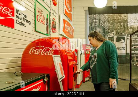 Eine Frau inspiziert eine antike Cola-Maschine, als sie durch das Coca-Cola Museum in Korinth, Mississippi, geht, 5. März 2012. Stockfoto