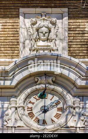 Eine Uhr- und Flachrelieffigur von Blind Justice sind Teil der architektonischen Details des historischen Alcorn County Courthouse in Corinth, Mississippi. Stockfoto